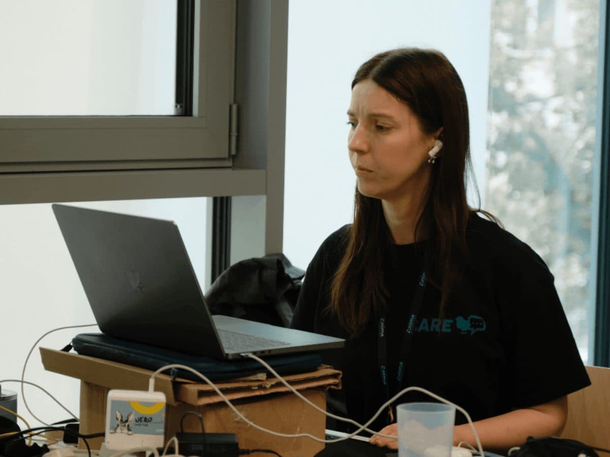 Ung kvinne sitter foran datamaskinen sin og jobber intenst